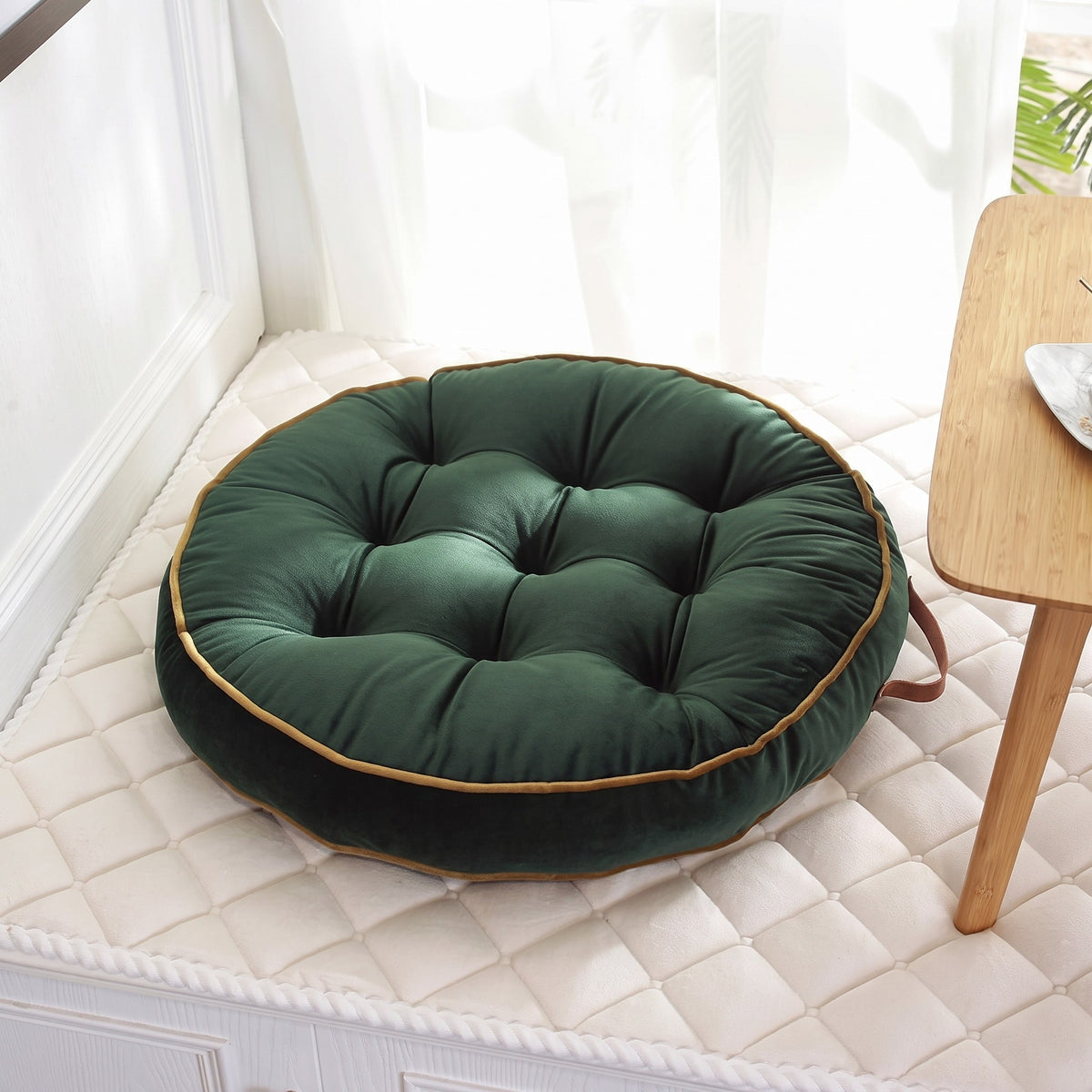 Coussin de sol rond façon tatami coloris vert, capitonnage en gros plan avec liseré doré