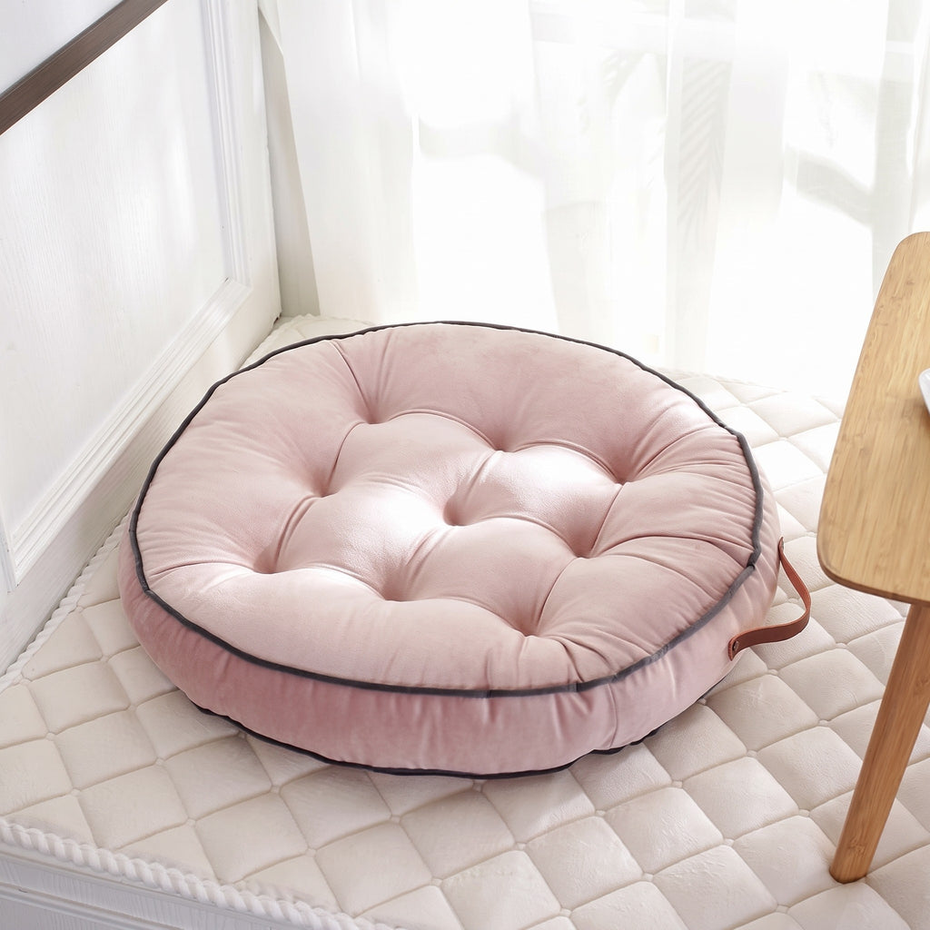 Coussin de sol rond façon tatami coloris rose, posé au sol dans un coin fenêtre