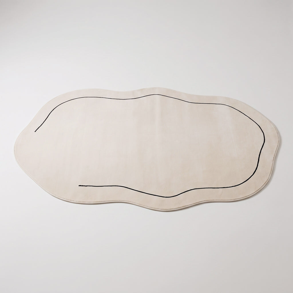 Tapis forme nuage écru vu en entier sur fond neutre, sa bordure gainée et son liseré noir