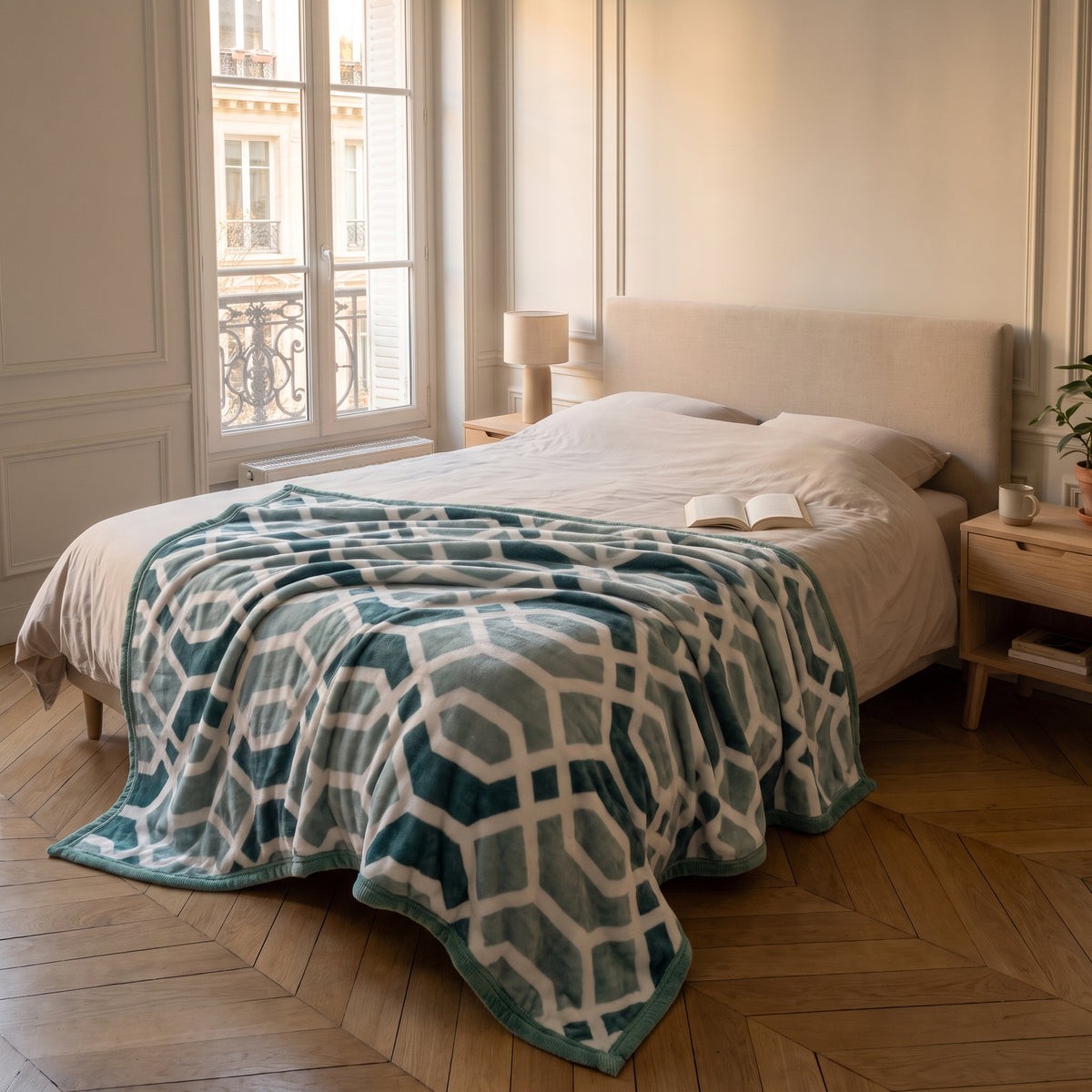 Plaid polaire à motifs déplié en travers d'un lit deux places