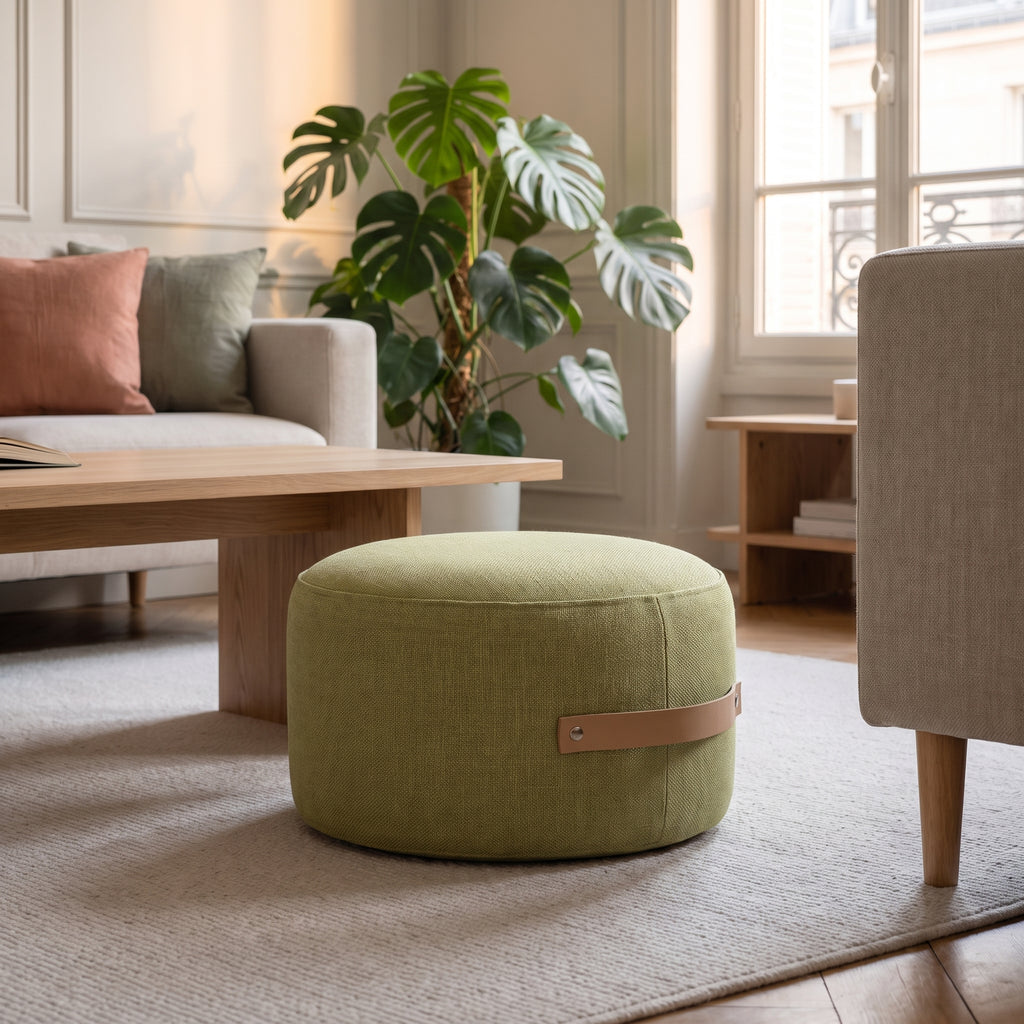 Pouf de sol rond vert anis posé sur le tapis du salon, poignée visible