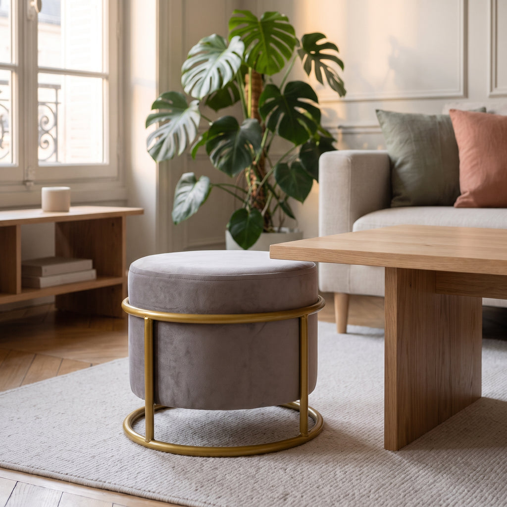Pouf réglable gris sur sa structure dorée, devant le canapé du salon