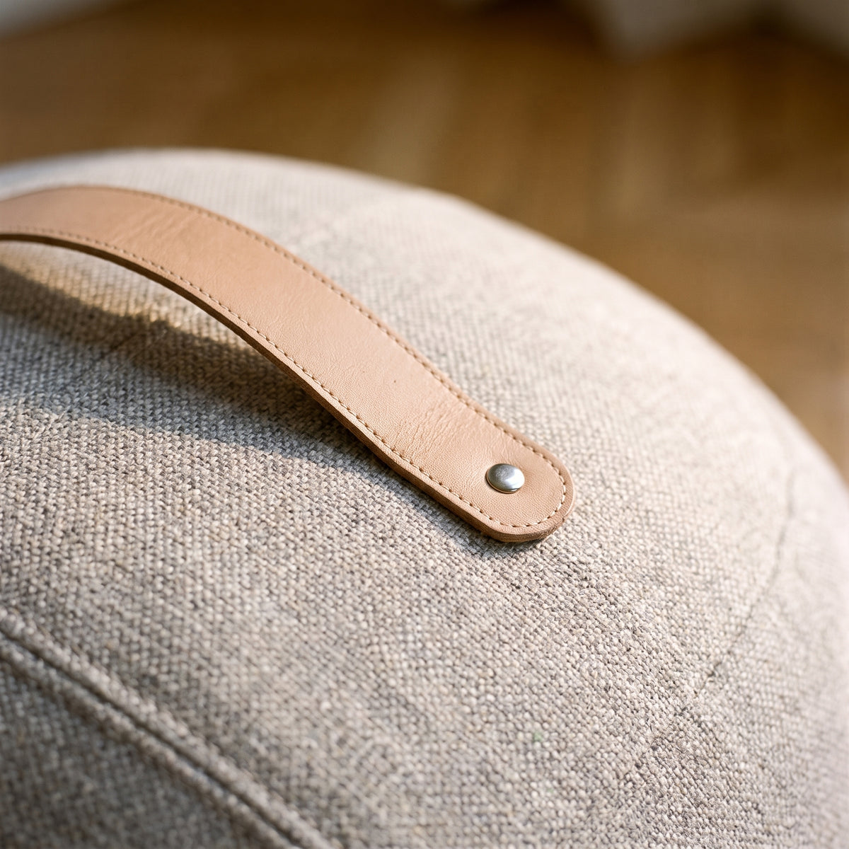 Détail de la poignée rivetée et de la trame tissée du pouf