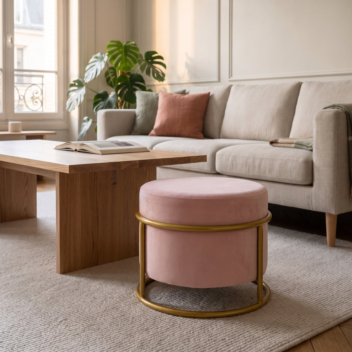 Pouf réglable rose sur sa structure dorée, devant le canapé du salon
