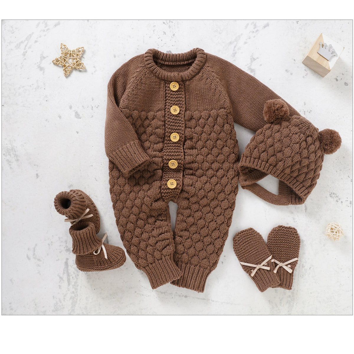 Ensemble quatre pièces en tricot marron pour bébé sur fond clair