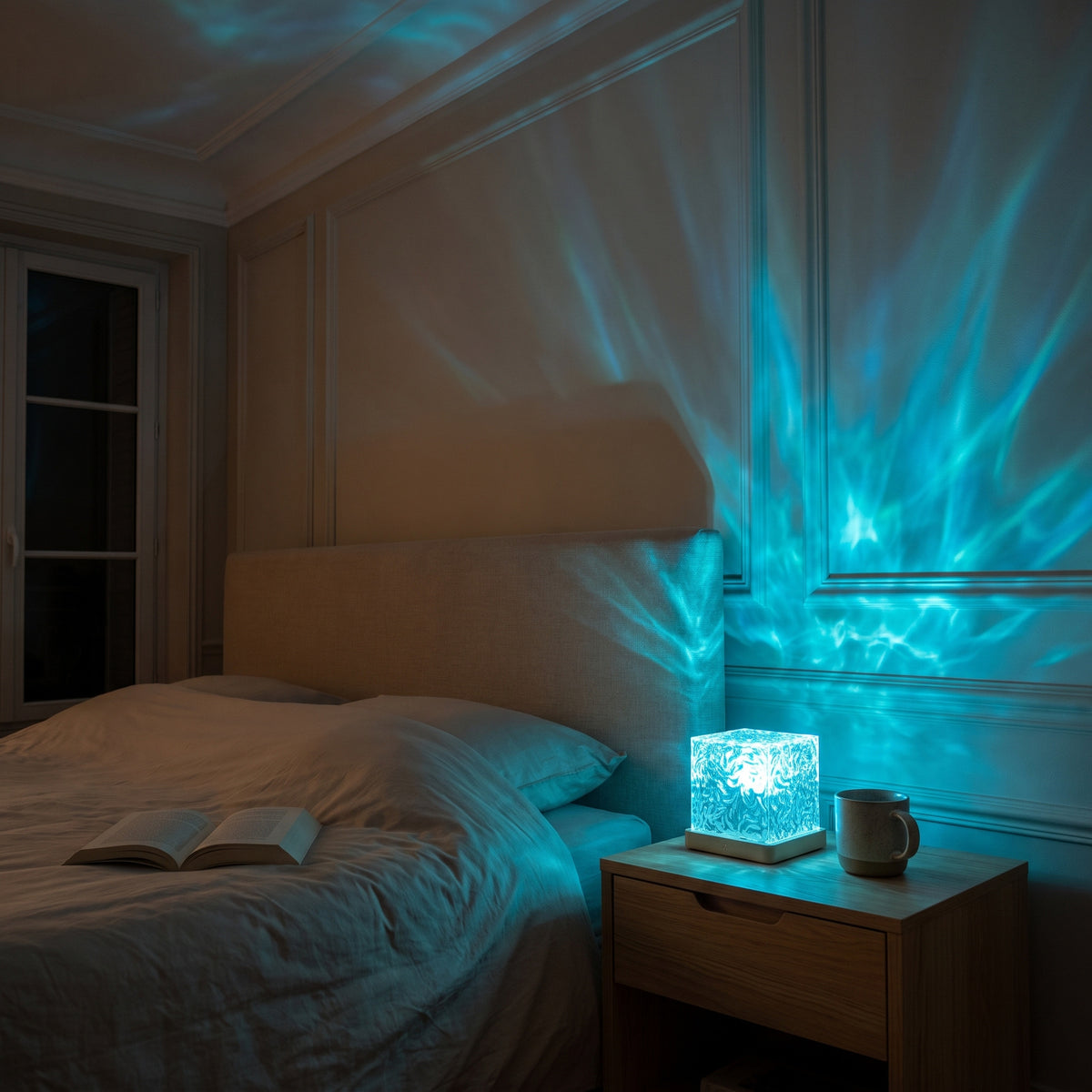 Veilleuse cube allumée en bleu sur une table de chevet, reflets d'eau sur le mur et le plafond de la chambre
