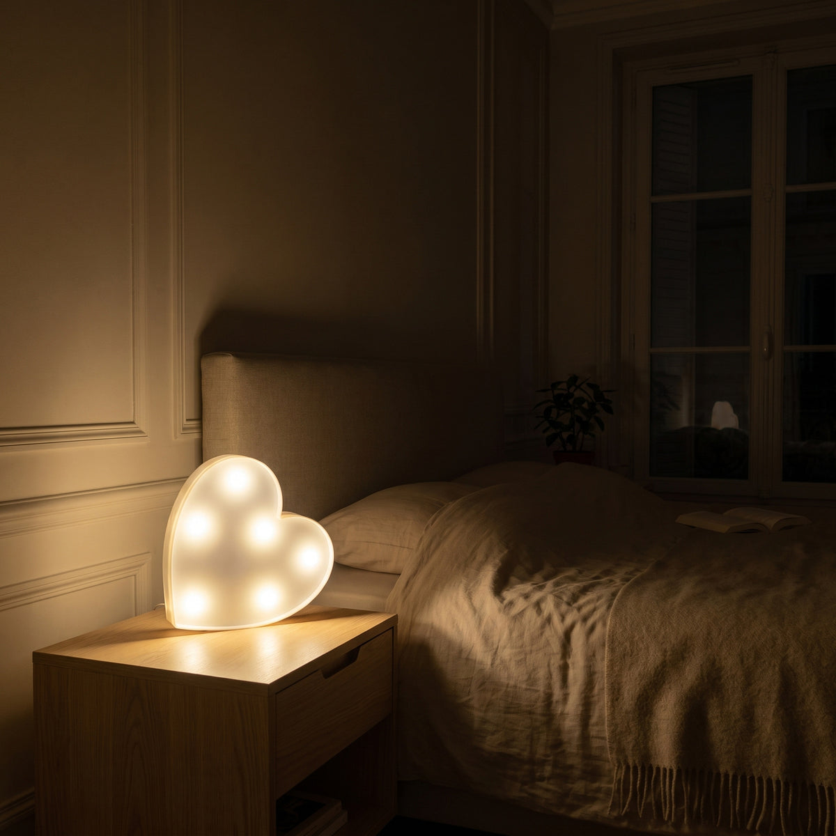 La veilleuse cœur est la seule lumière allumée de la chambre, la nuit tombée Image
