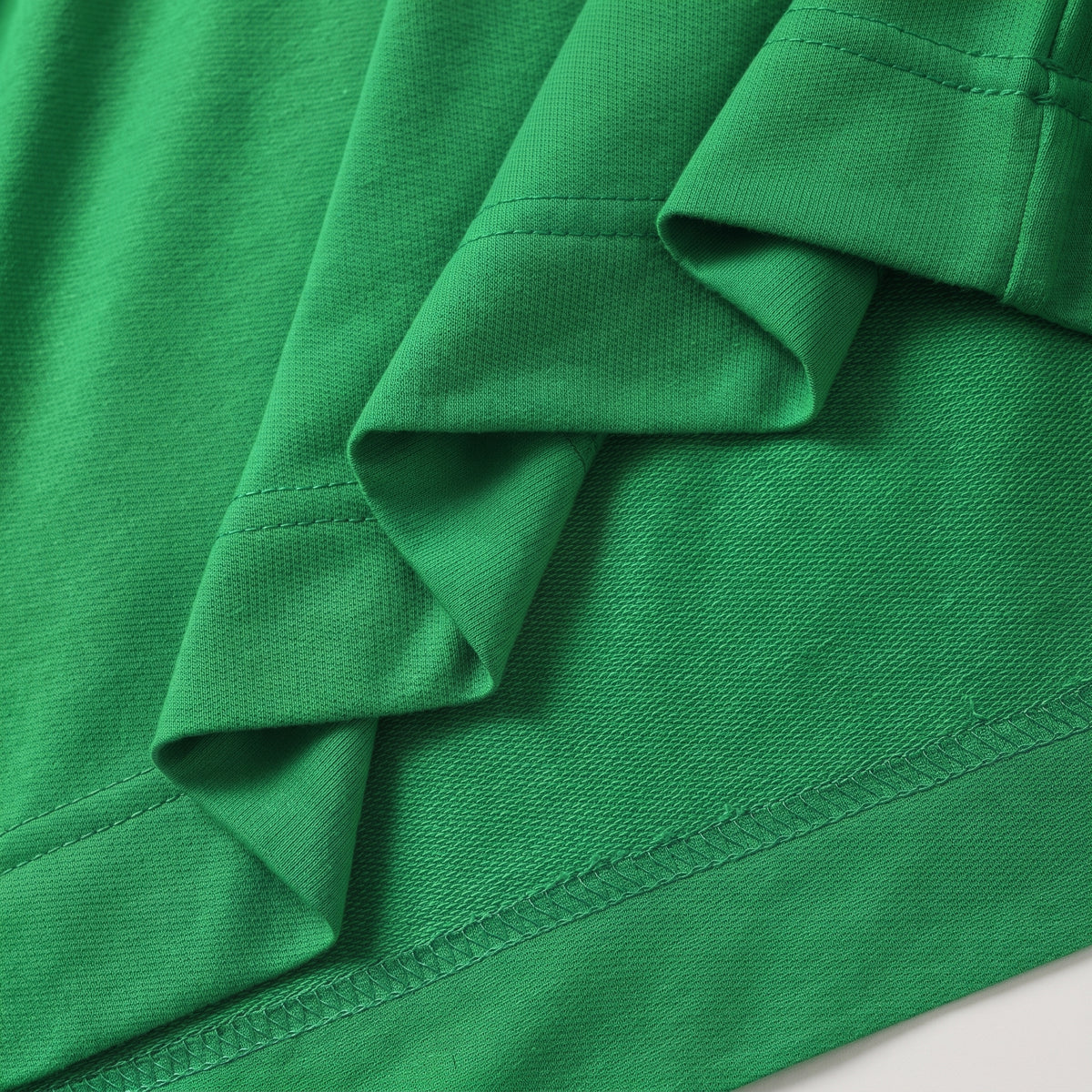 Détail du tombé, de la surface et des coutures de l’ensemble vert