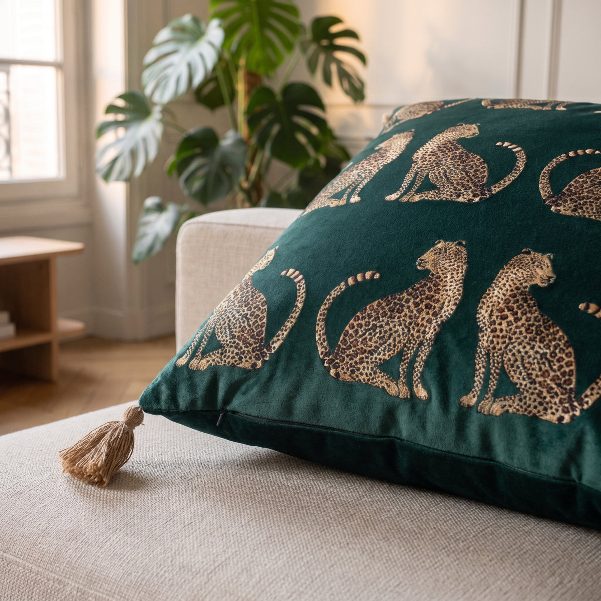 Détail du velours vert canard et du pompon d'angle de la housse de coussin léopard