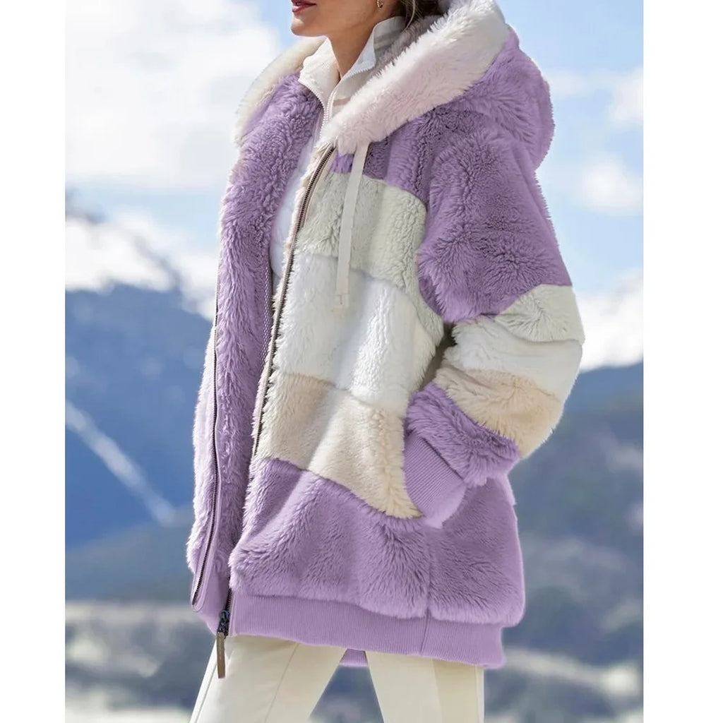 Veste violette en fausse fourrure portée de trois quarts, capuche blanche et panneaux gris, blanc et crème