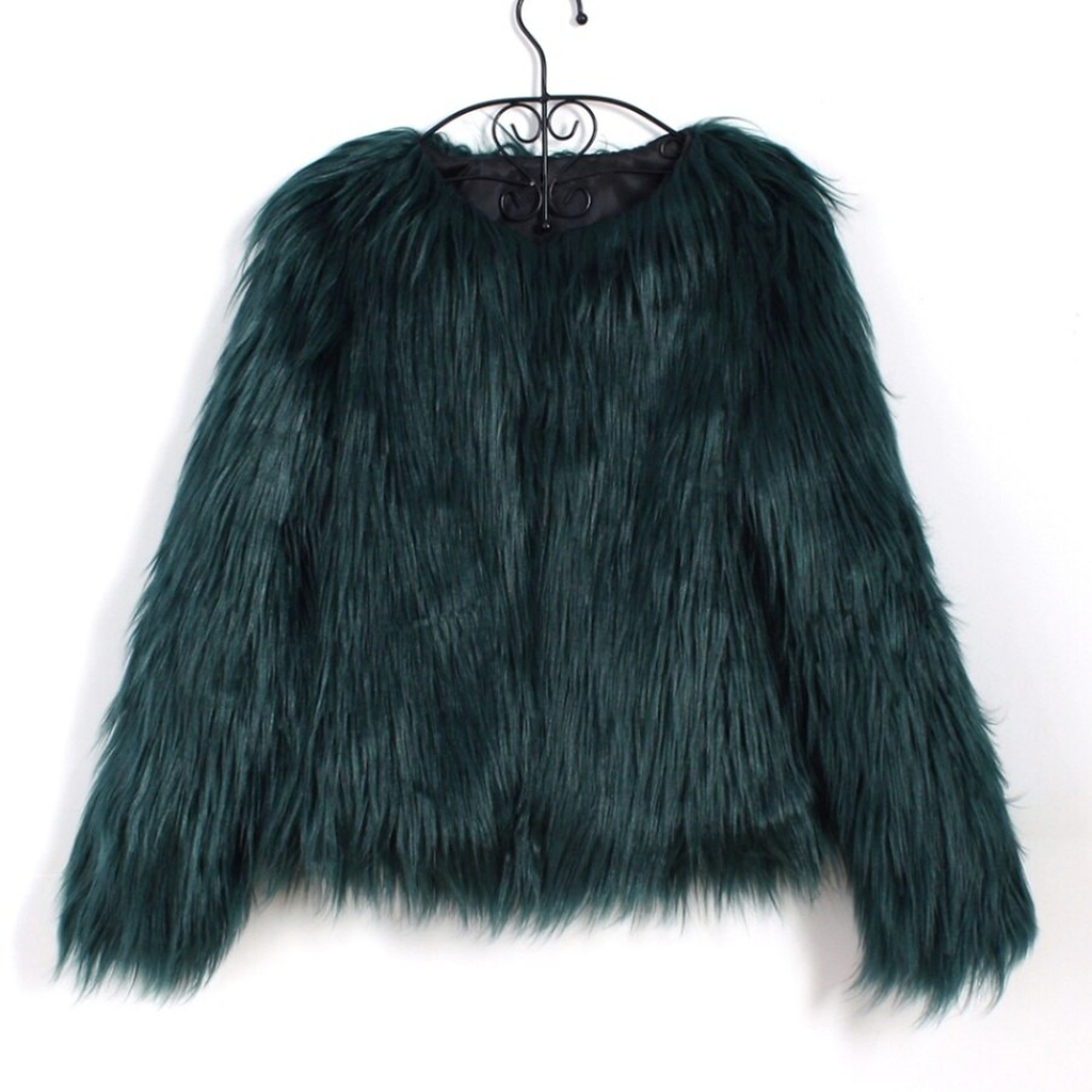 La veste vert sapin sur son cintre : le poil sombre absorbe la lumiere et les rangees se fondent, la doublure de l encolure est noire