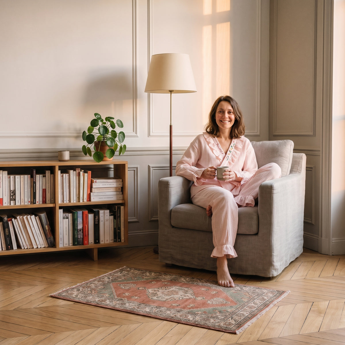 Pyjama en coton rose poudré porté dans un fauteuil de lecture